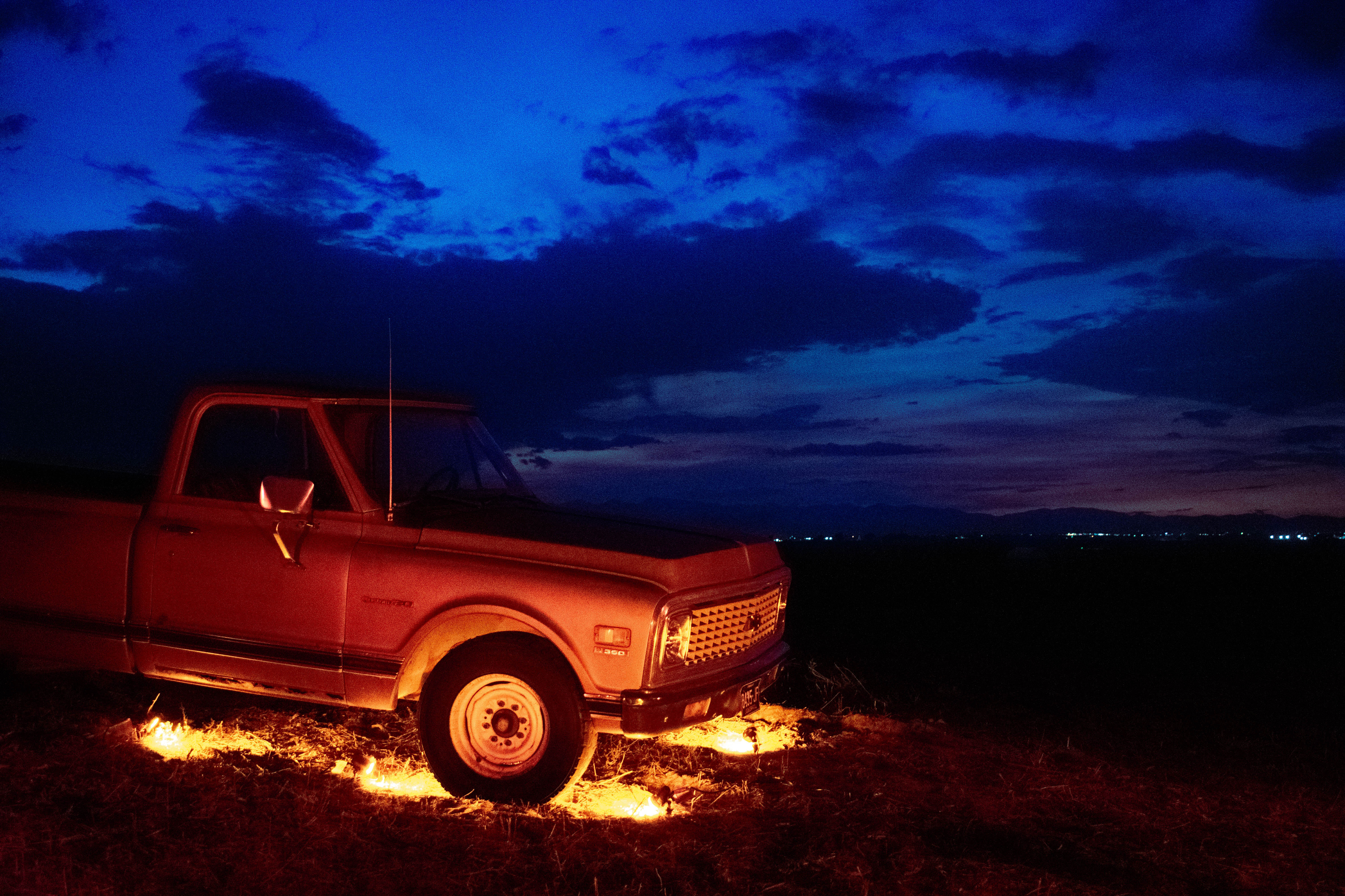 Vintage Chevy pickup glowing under a deep blue twilight sky